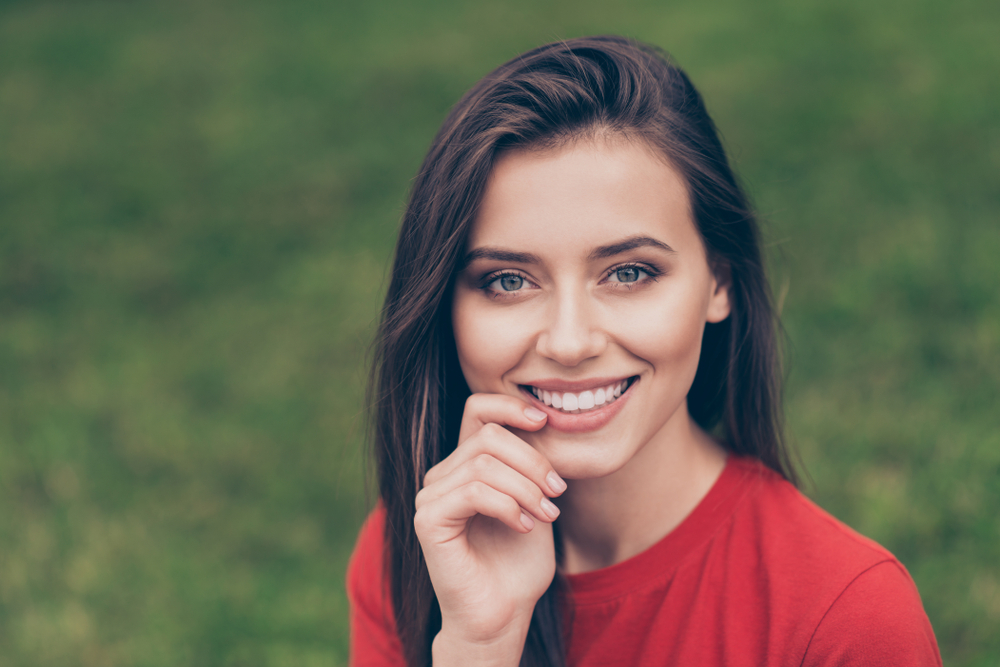 Teeth Whitening and Cosmetic Dentistry in Scotts Valley Young woman with long dark hair showing off her bright white smile outdoors, representing teeth whitening and cosmetic dentistry results in Scotts Valley, CA