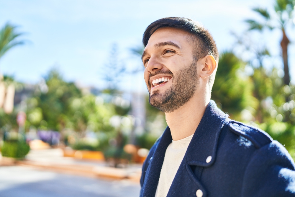 Family Dentist Serving Scotts Valley and the Santa Cruz Community Man with a bright, confident smile outdoors on a sunny day, representing patients who receive family dental care at Mt. Hermon Dental Care in Scotts Valley, CA